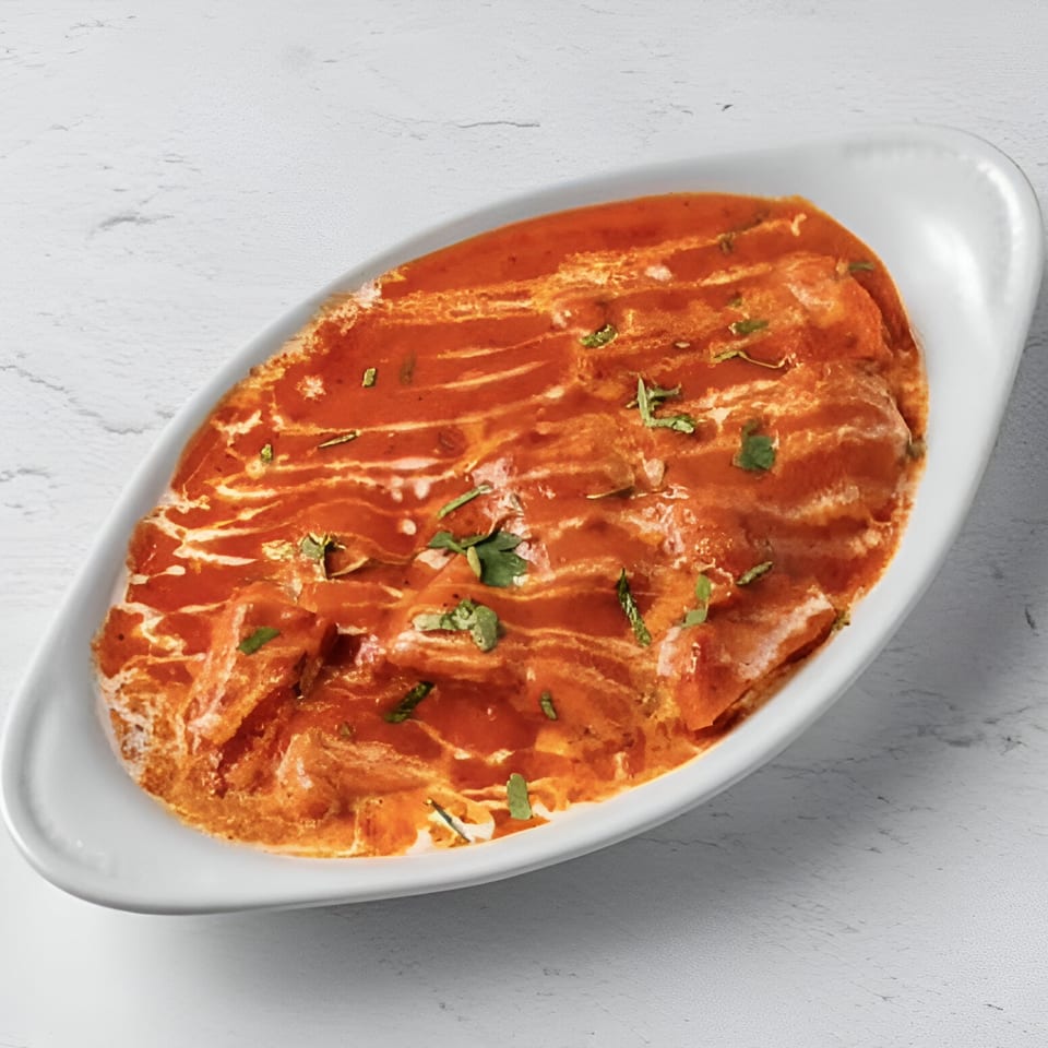 Taj Darbar Indian Cuisine's butter chicken, a rich orange curry with cream swirls and fresh herbs.