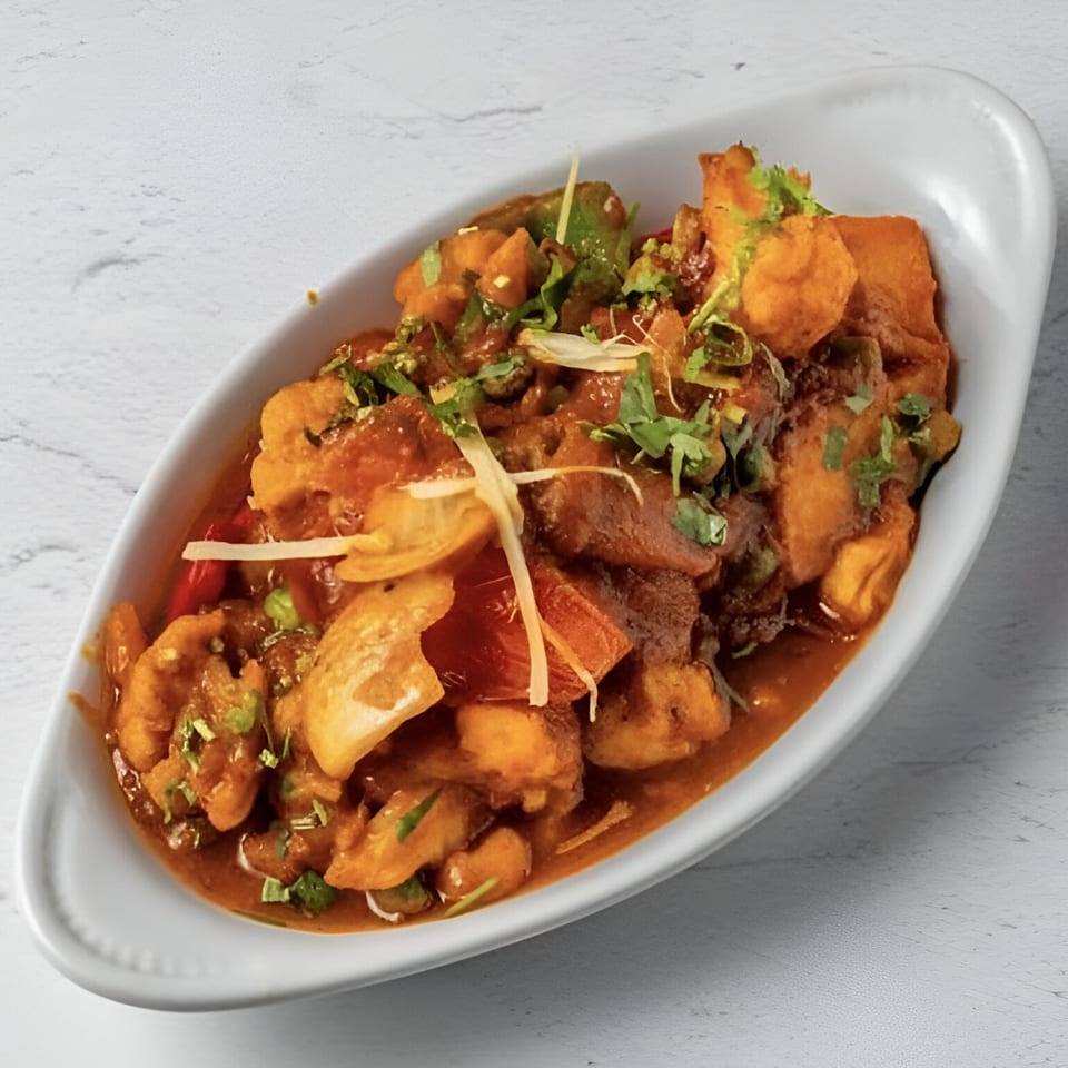 Taj Darbar Indian Cuisine's chili paneer, a vibrant dish with paneer, peppers, and onions in a rich sauce.